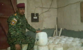 Binh sỹ Iraq bên cạnh những thùng trắng chứa vũ khí hóa học của IS