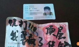 Tấm thẻ căn cước bọc trong tờ tiền mệnh giá 100 có viết lời cầu cứu 