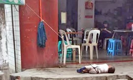 Em bé bị trói nằm ở vỉa hè