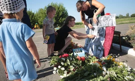 Dân làng đặt di ảnh một số hành khách xấu số của MH17 tại một khu tưởng niệm ở làng Petropavlivka, Donetsk, Ukraine