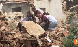 Máy xúc phá nhầm nhà, cả gia đình chạy lại dỡ đống đổ nát để cứu cụ Wang nhưng không kịp.