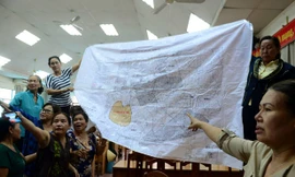 Trước khi buổi tiếp xúc cử tri diễn ra, một số người dân mang theo bản đồ quy hoạch 1/2.000 của khu đô thị mới Thủ Thiêm trưng trước hội trường. Ảnh: Zing 
