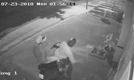 Hai thanh niên đi xe máy đến trước cửa nhà nạn nhân.