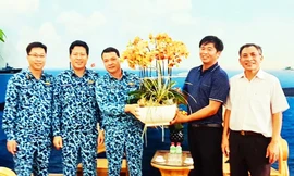 Anh Sang (áo xanh bên phải) tặng hoa lan cho bộ đội Trường Sa