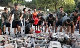 Binh sĩ Trung Quốc giúp dọn gạch đá trên đường phố Hong Kong. Ảnh: SCMP.