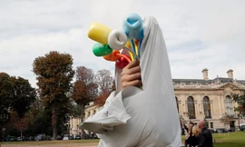 Nghệ sĩ Mỹ Jeff Koons và lãnh đạo thành phố Paris kéo màn khai trương tác phẩm “Bó hoa tulip”. Ảnh: AP.