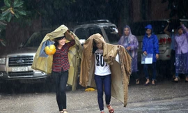 Thí sinh đội mưa đến trường thi