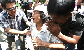 Cảnh sát mặc thường phục tiếp cận trước khi bắt giữ một người biểu tình.