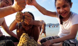 Niềm vui của hai bé khiếm thị Hồ Thị Ái Vy và bé Huỳnh Phan Anh Vũ, Trung tâm Hỗ trợ phát triển và hòa nhập Trẻ em khuyết tật tỉnh Đắk Lắk khi chơi trò xây núi cát ở bờ biển Hòn Tằm