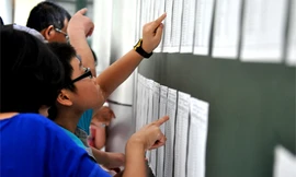  Học sinh kiểm tra số báo danh và phòng thi trong kì thi tuyển vào lớp 6 tại trường THCS Nguyễn Tất Thành. Ảnh: Quý Đoàn (VnExpress).