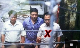 Dẫn giải Phan Thanh Bình (dấu X) ra xe - Ảnh: Nam Anh (Thanh Niên) 