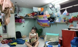 Mẹ vợ và con anh Nguyễn Văn Tuấn trong căn phòng trọ ở quận 11. Ảnh: DUY QUANG 