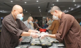  Thượng tọa Thích Thanh Phong (bìa trái), Trụ trì chùa Vĩnh Nghiêm chuẩn bị phần ăn gửi tặng các lực lượng chống dịch. Ảnh: NGÔ TÙNG