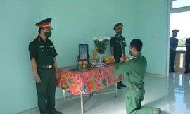 Binh nhì Nguyễn Huy Hoàng vọng bái mẹ trước bàn thờ được lập trong đơn vị. (Ảnh: B.N)