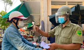 Người dân trước khi vào chợ đều phải xuất trình phiếu và được đo thân nhiệt. Ảnh: Nguyễn Ngọc