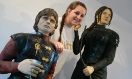 Cô Lara Clarke bên cạnh chiếc bánh mô phỏng nhân vật Tyrion Lannister và nhân vật Katniss.