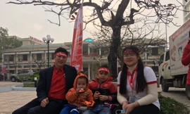 Hai tình nguyện viên trông giúp cháu nhỏ để bố mẹ các cháu hiến máu