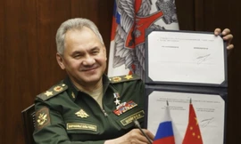 Bộ trưởng Quốc phòng Nga Sergei Shoigu giơ bản lộ trình hợp tác quân sự Nga - Trung đã ký với người đồng cấp Trung Quốc ngày 23/11. (Ảnh: AP)