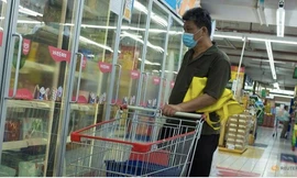 Một người đàn ông nhìn tủ chứa thực phẩm đông lạnh trong siêu thị ở Bắc Kinh. (Ảnh: Reuters)