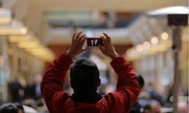 Một người đang dùng điện thoại chụp ảnh trong trung tâm thương mại ở Sydney, Úc. (Ảnh: Reuters)