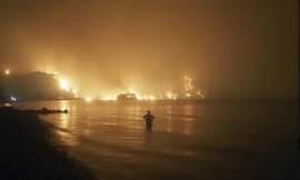 Một người đàn ông đang đứng nhìn đám cháy rừng nghiêm trọng ở Hy Lạp. (Ảnh: AP)