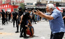 Một người đàn ông phản ứng khi cảnh sát bắt một người biểu tình ở Tunis ngày 25/7. (Ảnh: Reuters)