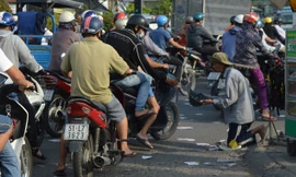 Ông Lương xin tiền tại ngã ba trước khu công nghiệp Tân Bình. Ảnh: Ngô Bình