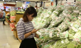 Người dân “soi” rau bằng điện thoại.