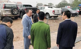 Có đủ lực lượng trong tay, nhưng sáng 22/2 khi được đại diện HĐND Hà Nội chất vấn, Phó Chủ tịch quận Tây Hồ Nguyễn Lê Hoàng (thứ 2, từ trái) chỉ đứng nhìn bãi xe lậu (phía sau) hoạt động.