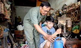 Ông Phạm Ngọc Tỉnh hướng dẫn sửa máy