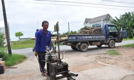 Ông Nguyễn Thanh Tâm đem đồ nghề vào nhà. Ảnh: Hòa Hội.