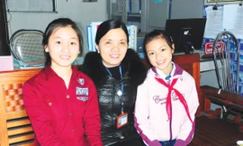 Ngô Kiều Anh (phải) và Nguyễn Thị Thu Hằng tự tin bên cạnh cô hiệu trưởng.