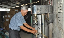 Ông Sáu Tia đang đóng nút chai bằng máy. Ảnh: Hòa Hội.