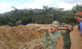 Các chiến sỹ giúp người dân dựng nhà ở nơi ở mới.