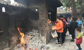 Bên cạnh sự chuyển biến tích cực, nhiều người dân vẫn đốt vàng mã tại chùa. Ảnh: Nguyên Khánh.