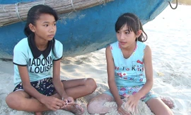 Hai cháu Thơm và Hòa ngồi ngóng cha ngoài biển để vơi đi nổi nhớ mẹ đang làm thuê ở miền Nam.