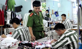 Hướng dẫn phạm nhân trong xưởng may. Ảnh: Xuân Tùng