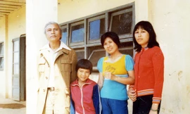 Quang Dũng chụp ảnh tại ngôi trường mà con gái (bìa phải) công tác ở huyện Lâm Hà.