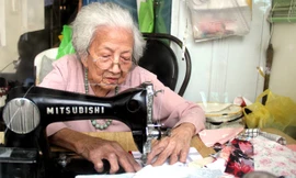 Bà Võ Thị Vân Khanh mải miết từng đường may để có những chiếc chăn ấm tặng người nghèo. Ảnh H. Văn