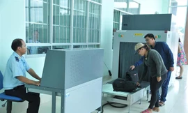 Hành khách cho hành lý đi qua máy soi chiếu của hải quan để kiểm tra. Ảnh: Tuấn Nguyễn.