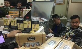 Đối tượng và tang vật một vụ buôn lậu thuốc lá ngoại số lượng lớn bị Công an Hà Nội bắt giữ.