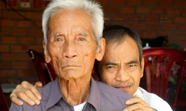 Đã 92 tuổi, cụ Huỳnh Văn Truyện (phía trước) vẫn chưa thể dừng lại trên con đường mang lại công lý cho con trai mình, ông Huỳnh Văn Nén (phía sau).