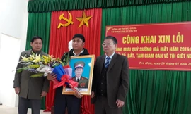 Đại diện gia đình ông Mưu Quý Sường tiếp nhận lời xin lỗi và nhận hoa từ đại diện chính quyền địa phương.