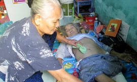 Bà Quế tận tình chăm sóc bà Anh. Ảnh: Giang Thanh