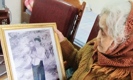 Cụ Khương Thị Chu- mẹ liệt sĩ Lê Đình Chinh- với bức ảnh kỷ niệm Chinh hồi nhỏ. Ảnh: Hoàng Lam