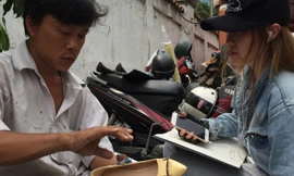 Đo mẫu làm lại giày cho khách.