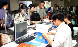 Cán bộ cơ quan hành chính thủ tục một cửa ở Hà Nội đang làm thủ tục phục vụ người dân. Ảnh: Hồng Vĩnh.