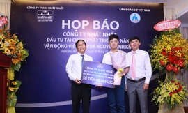 Ông Trần Thái Hoàng - Đại diện Công ty Dược phẩm Nhất Nhất trao gói đầu tư tài chính cho kỳ thủ Nguyễn Anh Khôi.