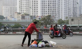 Một người phụ nữ thản nhiên đổ rác ra giữa đường Nguyễn Trãi, đoạn gần cầu vượt Ngã tư Sở (Hà Nội). Ảnh: Trường Phong