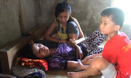 Hai con thơ vừa bóp chân tay cho mẹ vừa khóc, vì bố XKLĐ ở Angola vừa qua đời vì sốt rét, gia đình chưa có tiền đem thi thể về nước.